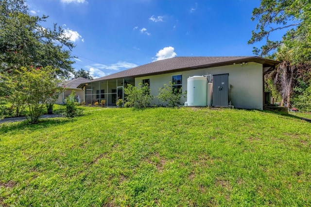 rear view of property featuring a lawn