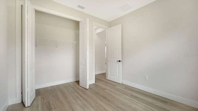 unfurnished bedroom featuring a closet and light wood-type flooring