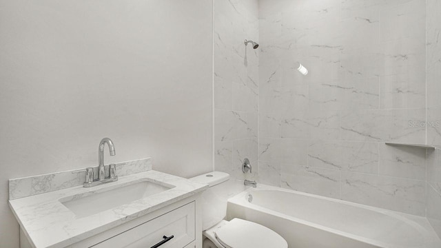 full bathroom featuring tiled shower / bath, vanity, and toilet