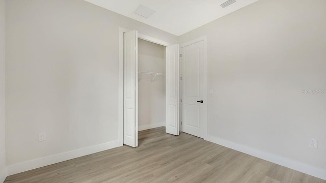 unfurnished bedroom with light hardwood / wood-style floors and a closet