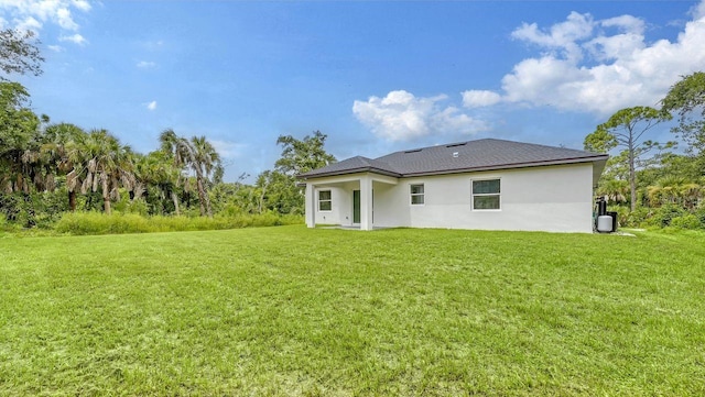 rear view of property with a yard