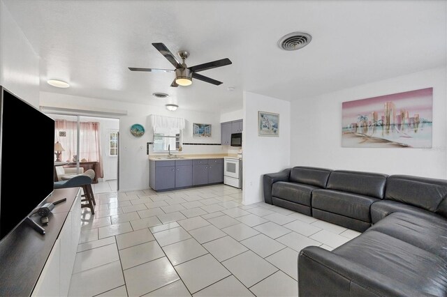 tiled living room with sink and ceiling fan