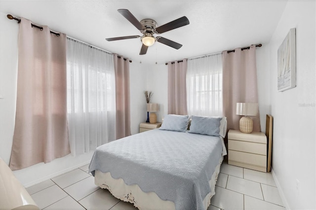 bedroom featuring multiple windows, light tile patterned floors, and ceiling fan