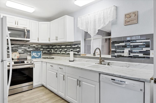 kitchen with light hardwood / wood-style flooring, sink, appliances with stainless steel finishes, and white cabinets