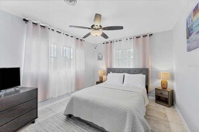 bedroom with ceiling fan and light tile patterned floors