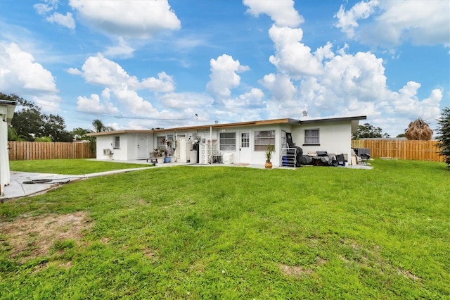 rear view of property featuring a patio area and a lawn