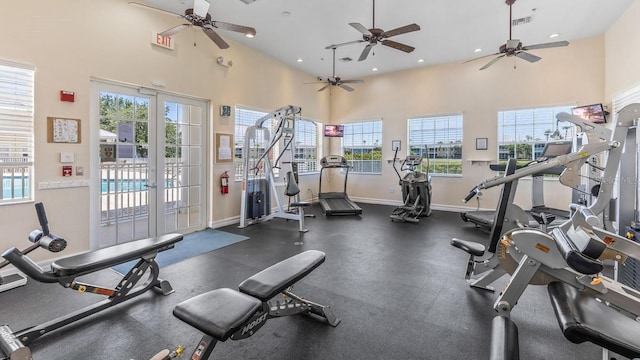 exercise room featuring a towering ceiling and french doors