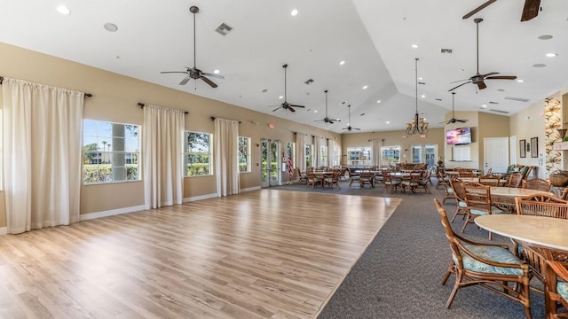 dining space featuring light wood-type flooring and high vaulted ceiling