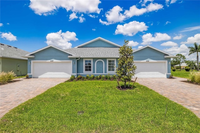 ranch-style home with an attached garage, stucco siding, decorative driveway, and a front yard