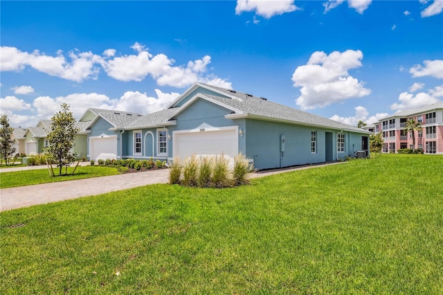 view of front of house featuring a garage, driveway, a front lawn, and stucco siding