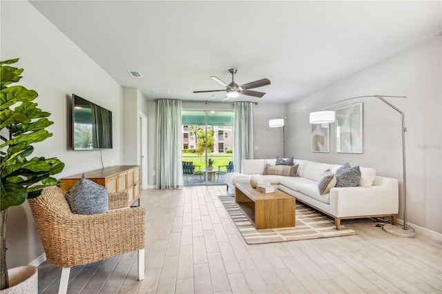 living room featuring ceiling fan and light hardwood / wood-style flooring