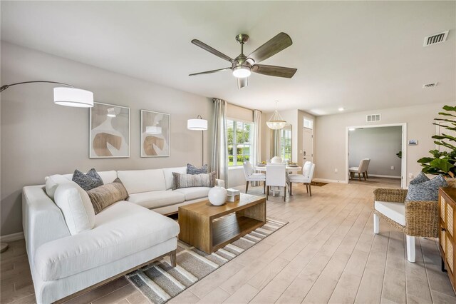 living room with ceiling fan and light hardwood / wood-style floors