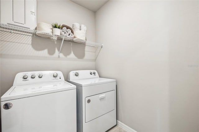 washroom featuring laundry area, washing machine and clothes dryer, and baseboards