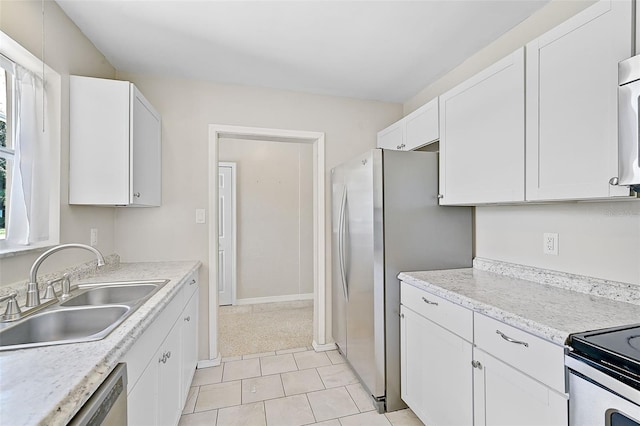 kitchen with white cabinets, light colored carpet, appliances with stainless steel finishes, and sink