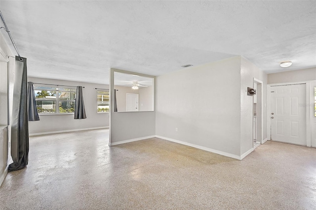 spare room featuring a textured ceiling and ceiling fan