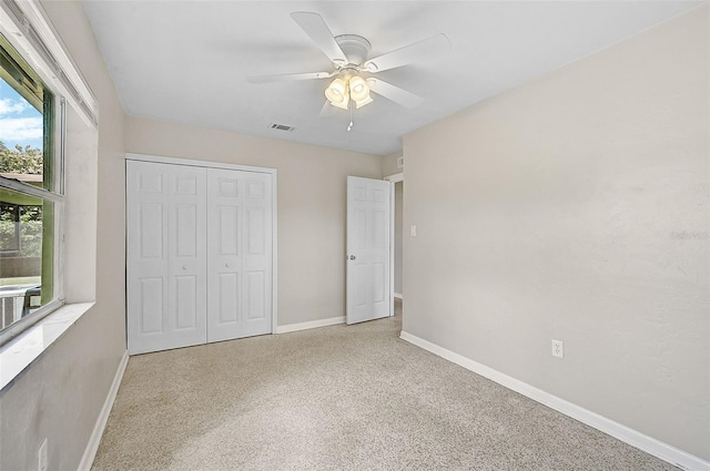 unfurnished bedroom with light carpet, a closet, and ceiling fan