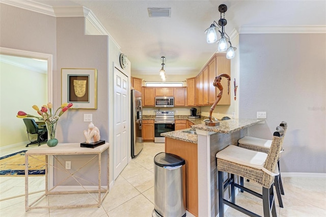 kitchen with appliances with stainless steel finishes, a breakfast bar, pendant lighting, and kitchen peninsula