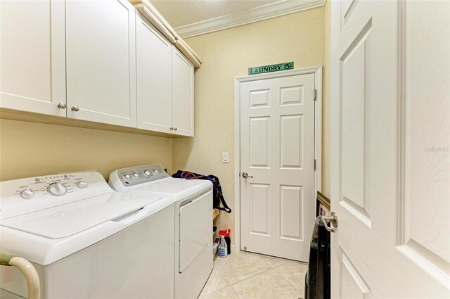 clothes washing area featuring cabinets, washing machine and dryer, ornamental molding, and light tile patterned flooring