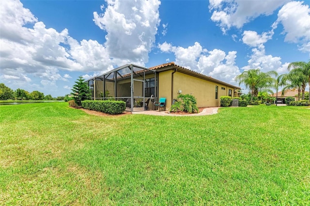 back of property featuring a lawn and glass enclosure