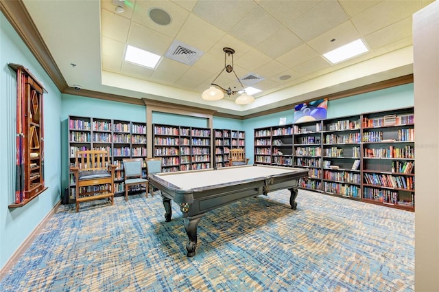 rec room with a raised ceiling, ornamental molding, carpet floors, and a drop ceiling