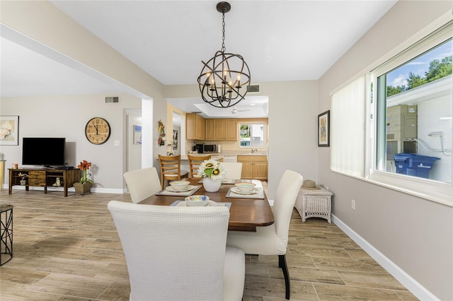 dining room with sink, a wealth of natural light, and an inviting chandelier