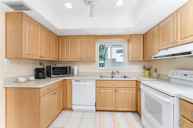 kitchen featuring a raised ceiling, sink, white appliances, and light tile patterned flooring