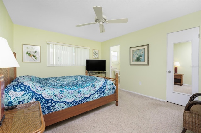 bedroom featuring light carpet, ceiling fan, and ensuite bath