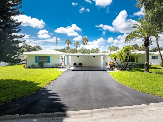 view of front of property with a front lawn and a carport