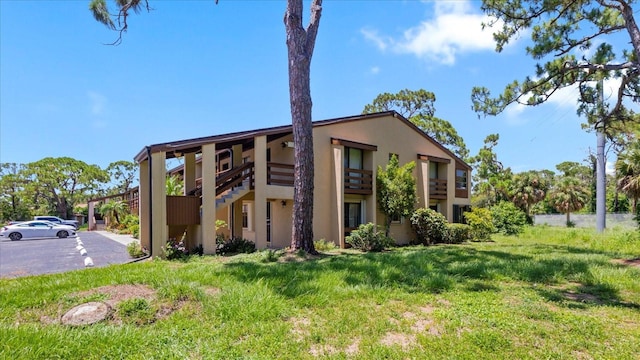 townhome / multi-family property with stucco siding and a front lawn