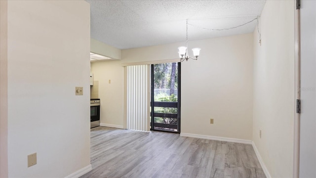 unfurnished room with a chandelier, baseboards, a textured ceiling, and wood finished floors