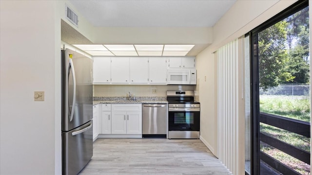 kitchen featuring white cabinets, plenty of natural light, visible vents, and appliances with stainless steel finishes