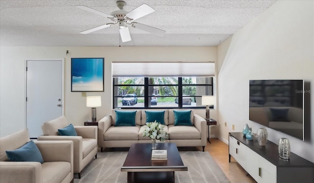 living room featuring ceiling fan, baseboards, and a textured ceiling