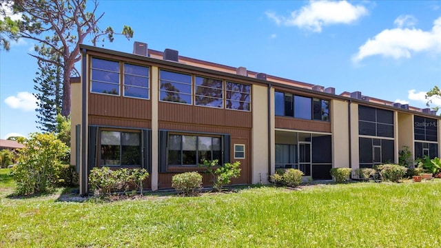 rear view of property featuring a lawn