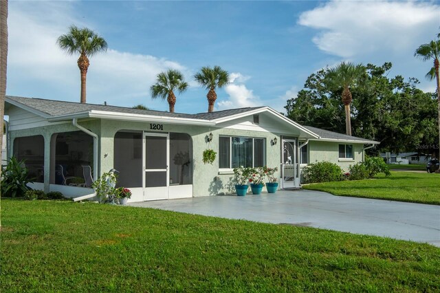 view of front of house featuring a sunroom and a front yard