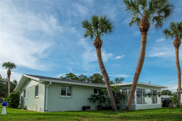 rear view of house with a sunroom and a yard