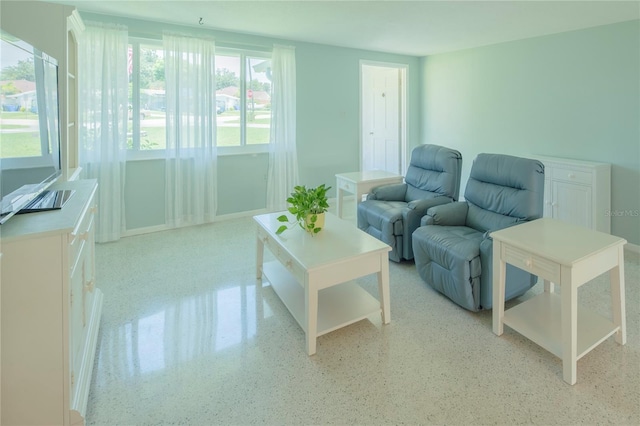 living area featuring light speckled floor