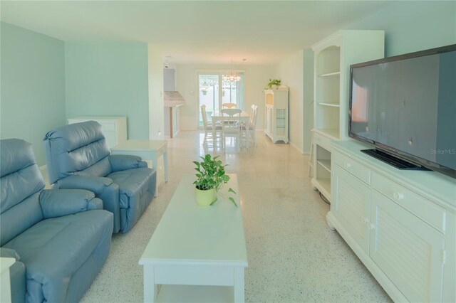 living area with light speckled floor and an inviting chandelier