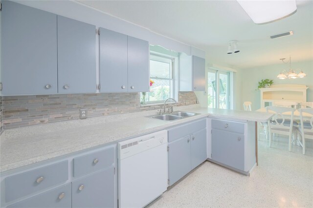 kitchen featuring a chandelier, sink, white dishwasher, kitchen peninsula, and backsplash