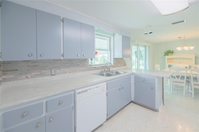 kitchen with white dishwasher, a peninsula, visible vents, light countertops, and hanging light fixtures