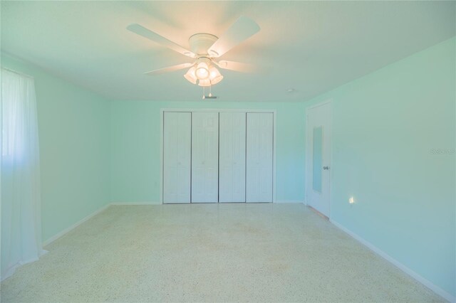 unfurnished bedroom featuring baseboards, a ceiling fan, light speckled floor, and a closet