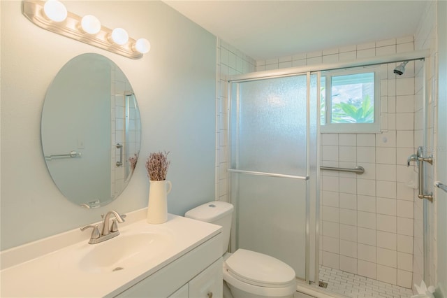 bathroom with a shower with door, toilet, and vanity