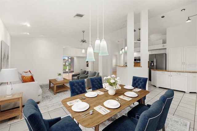 dining space featuring ceiling fan, lofted ceiling, and light tile patterned flooring