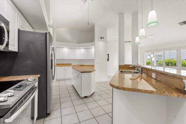 kitchen with sink, a center island, light tile patterned floors, pendant lighting, and white cabinets