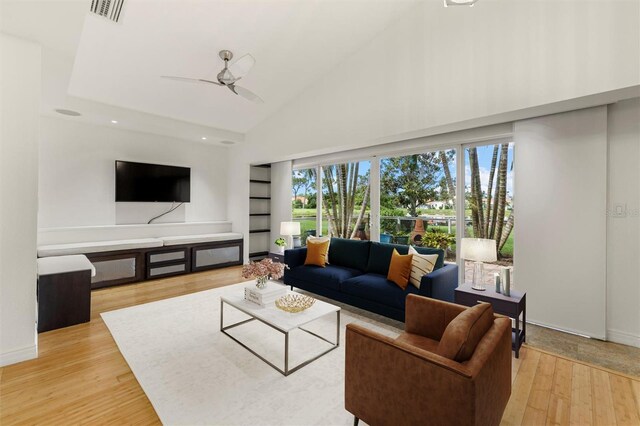 living room featuring high vaulted ceiling, ceiling fan, and light wood-type flooring