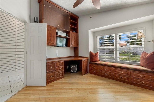 office featuring light hardwood / wood-style floors, built in desk, and ceiling fan