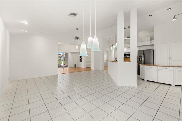 kitchen with appliances with stainless steel finishes, decorative light fixtures, light hardwood / wood-style floors, white cabinetry, and ceiling fan