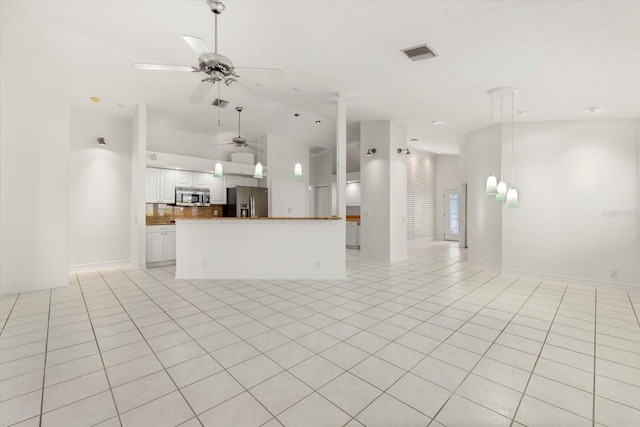 kitchen featuring light tile patterned flooring, appliances with stainless steel finishes, decorative backsplash, ceiling fan, and white cabinets