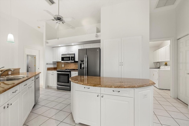 kitchen featuring sink, high vaulted ceiling, appliances with stainless steel finishes, a kitchen island, and white cabinetry