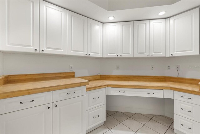 unfurnished office featuring light tile patterned floors and built in desk