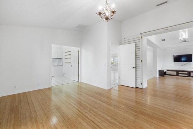 tiled empty room with high vaulted ceiling and a chandelier